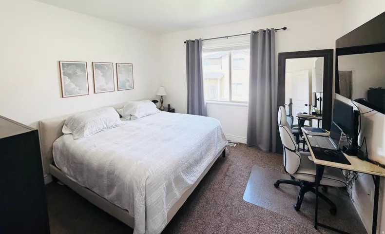 Window with curtain rod, neutral wall paint, and brown carpet