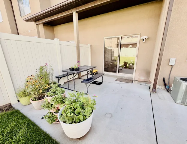 Covered concrete patio with sliding glass door access