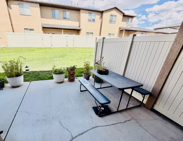 Concrete patio with privacy fencing and a grassy outdoor area