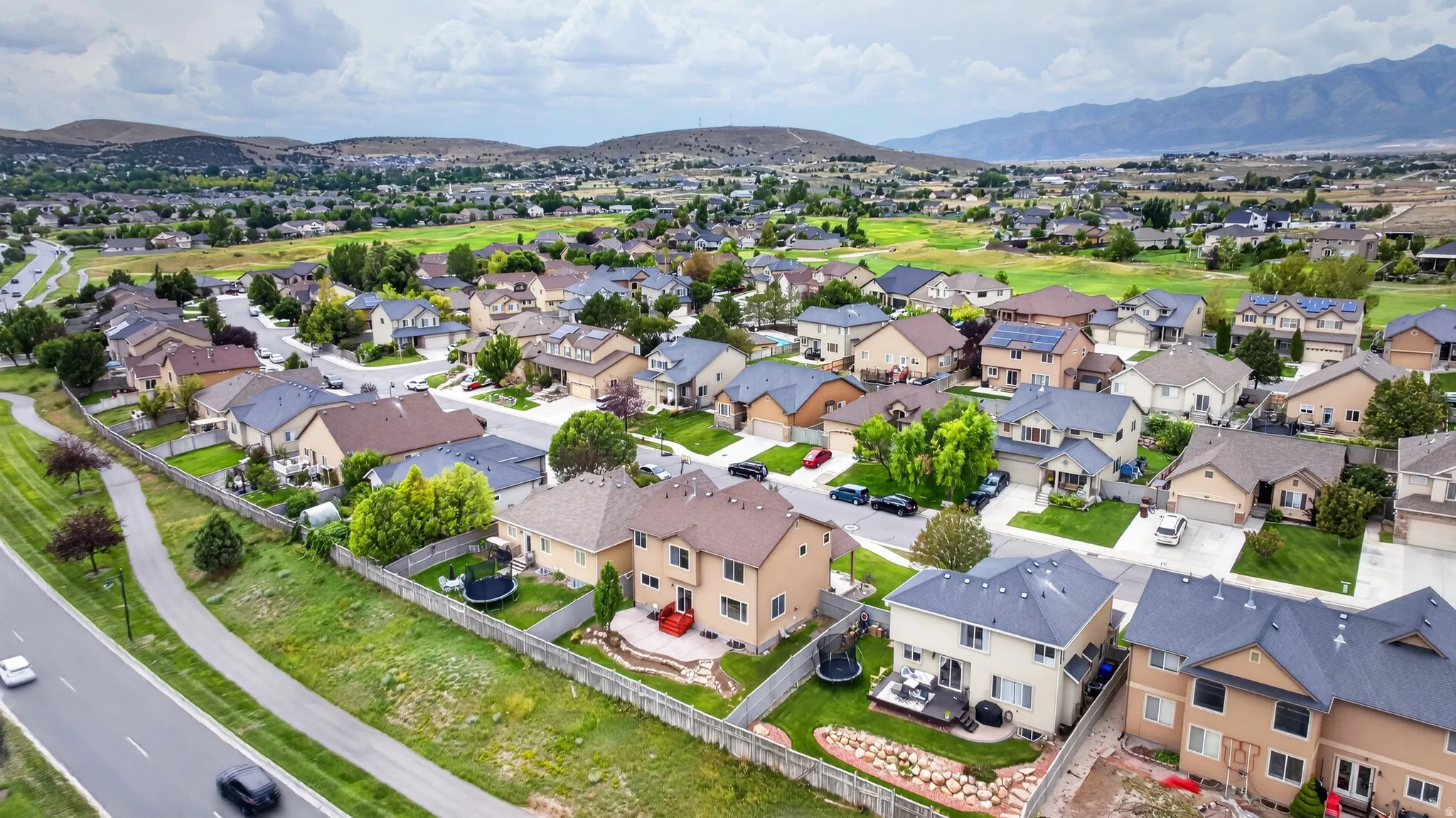 Residential neighborhood with varied architectural styles, paved streets, and mountain backdrop