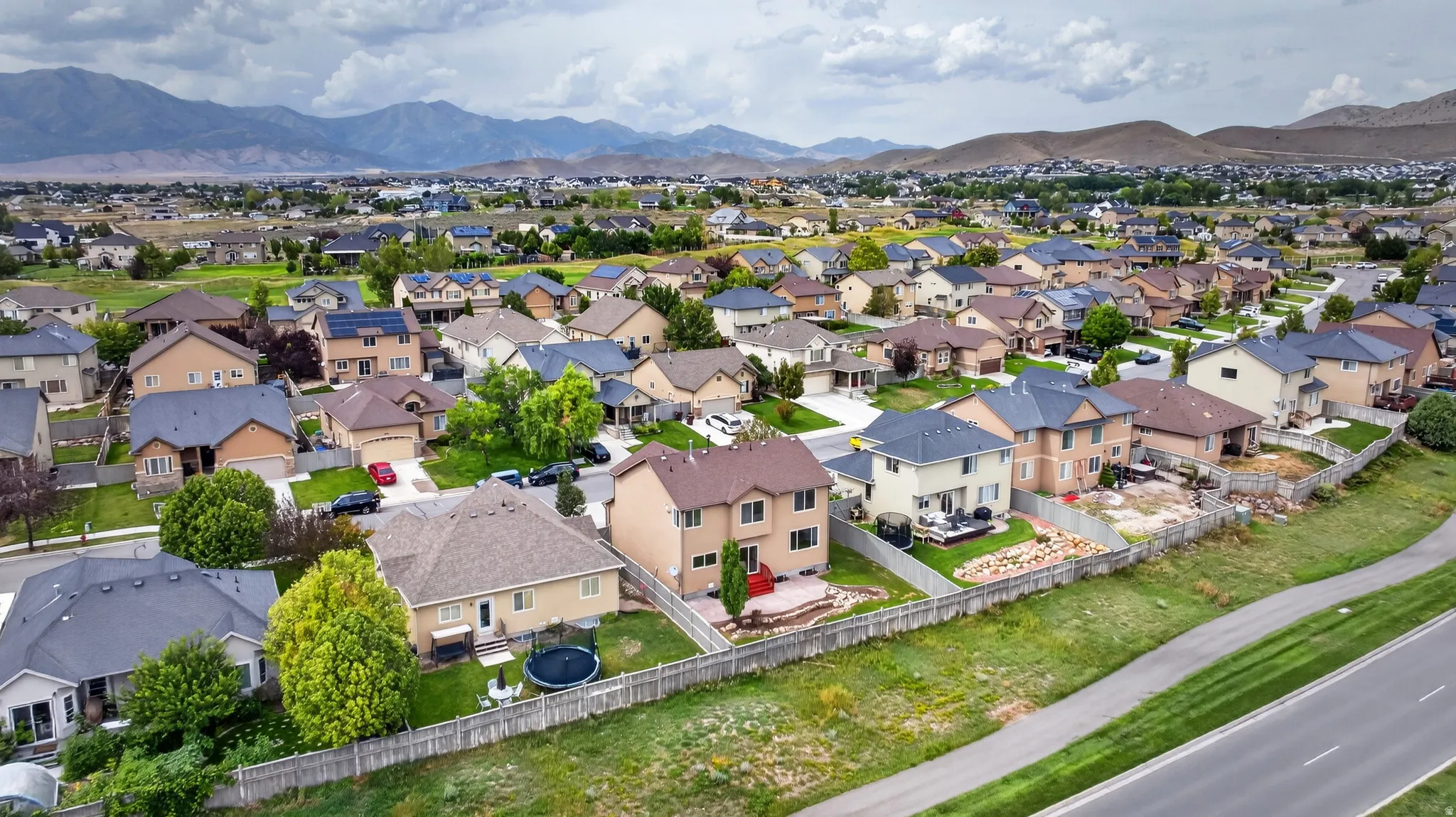 Residential neighborhood with varied rooflines and mature landscaping, set against a mountainous backdrop