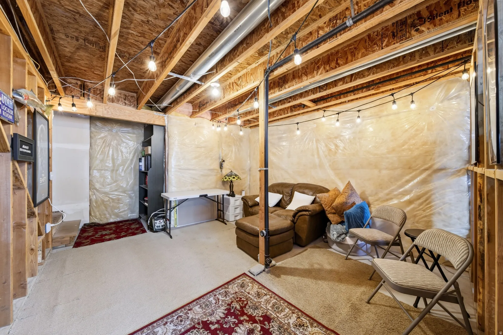 Unfinished basement area featuring exposed wood joists and string lighting