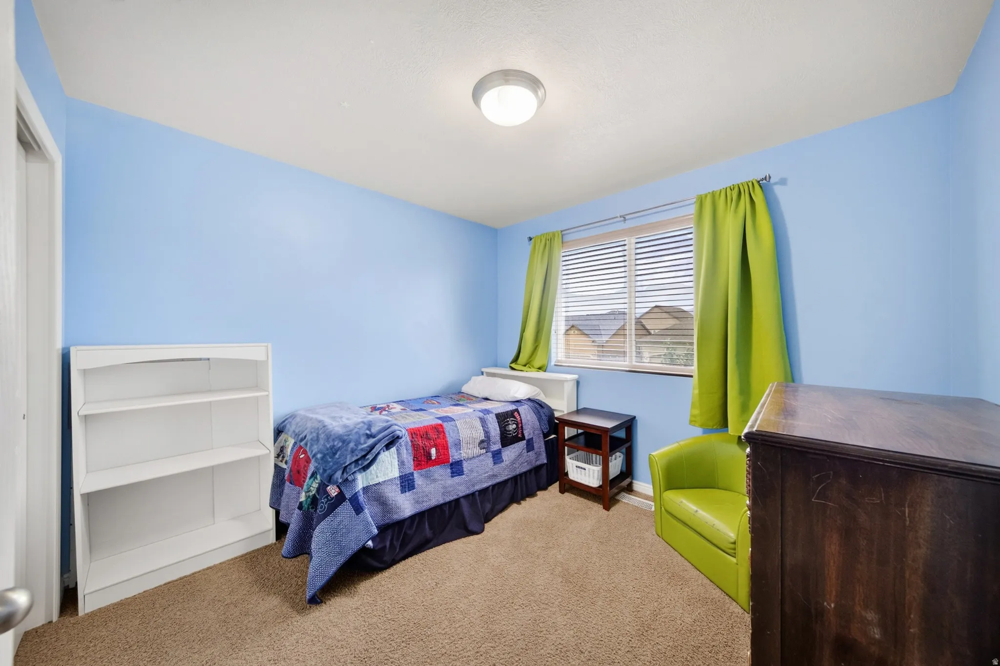 Carpeted room with a window featuring horizontal blinds, a ceiling-mounted light fixture, and blue painted walls