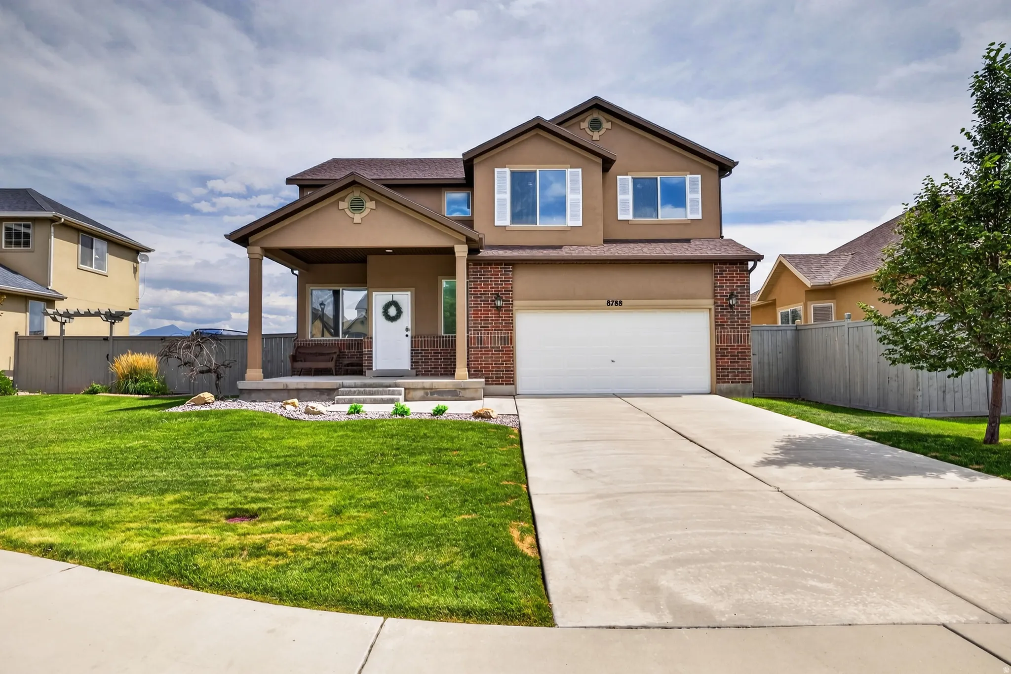 Two-story residence featuring a covered front porch with columns, an attached garage, and a concrete driveway