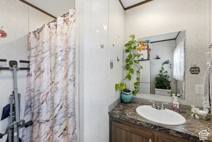 Vanity with an integrated oval sink, stone-look countertop, and wood-finish cabinetry