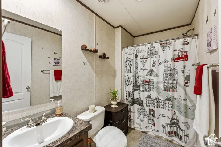 Bathroom featuring a single vanity with an integrated sink, a built-in shower, and textured wall coverings