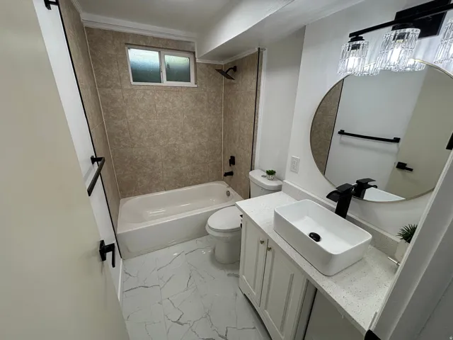 Bathroom featuring a white vanity with quartz countertop, vessel sink, and matte black fixtures
