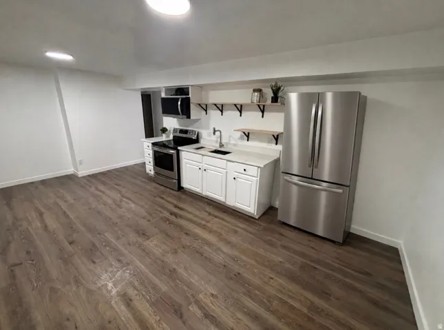 Wood-finish flooring with white walls and overhead lighting