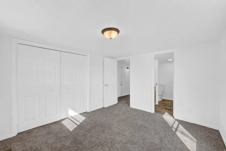 Wall-to-wall carpeting with a neutral finish, white bi-fold closet doors, and recessed ceiling lighting