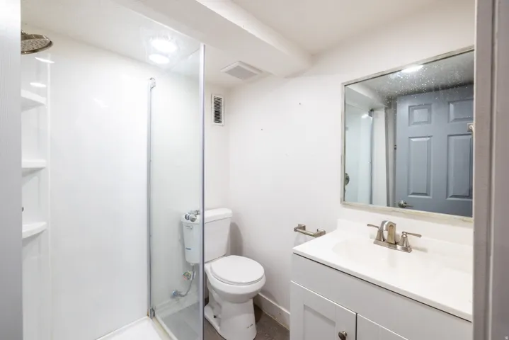 White vanity with brushed nickel hardware, integrated sink, and brushed nickel faucet