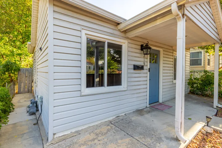 Siding exterior featuring a covered entry, blue front door, and an exterior wall lantern