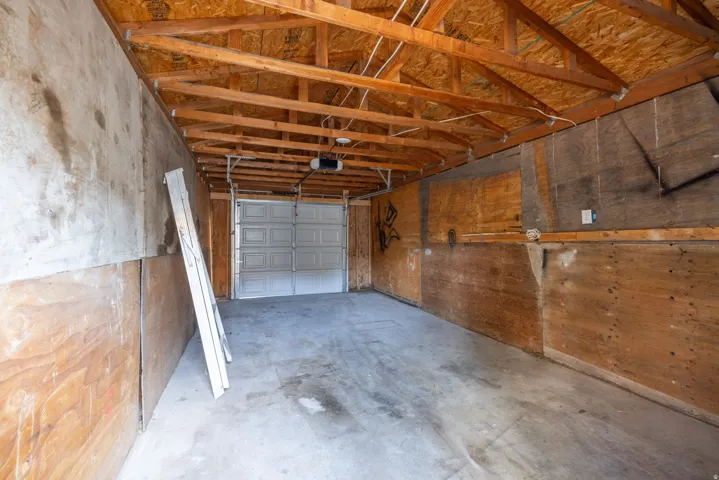 Exposed wood ceiling joists and plywood walls