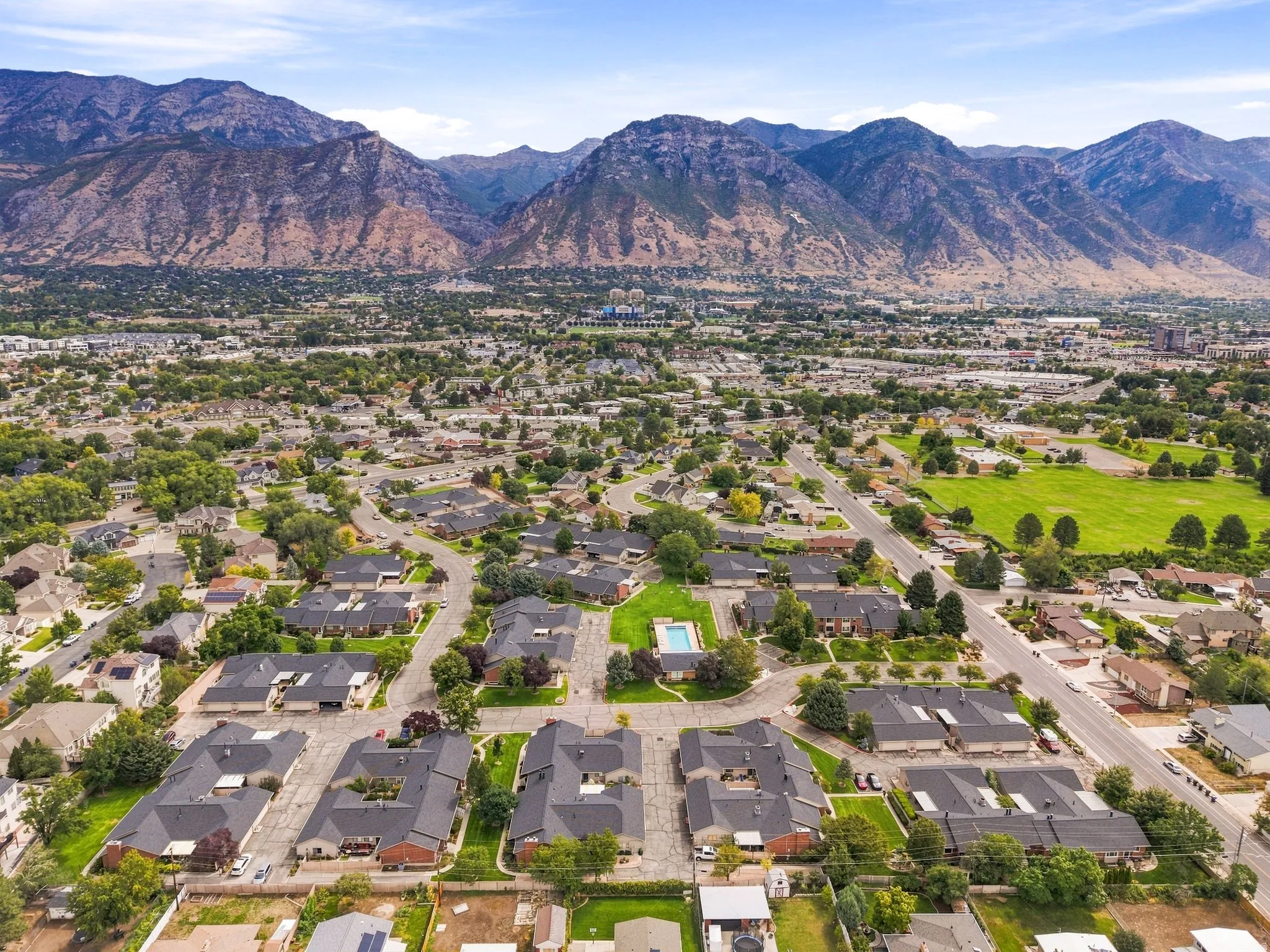 Expansive neighborhood featuring residential properties, mature trees, and a community pool