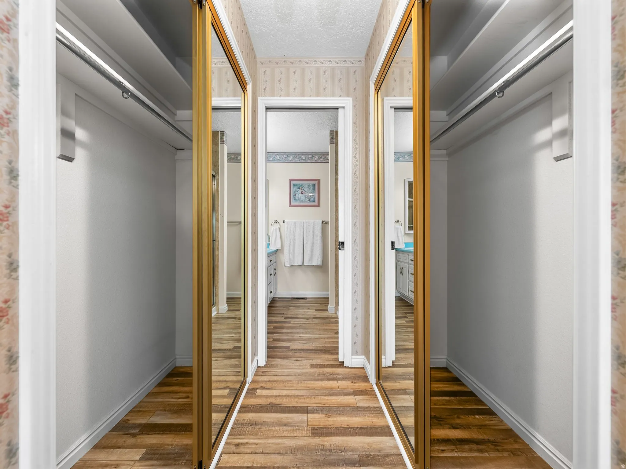 Wood-finish flooring leading to a bathroom with a light blue countertop
