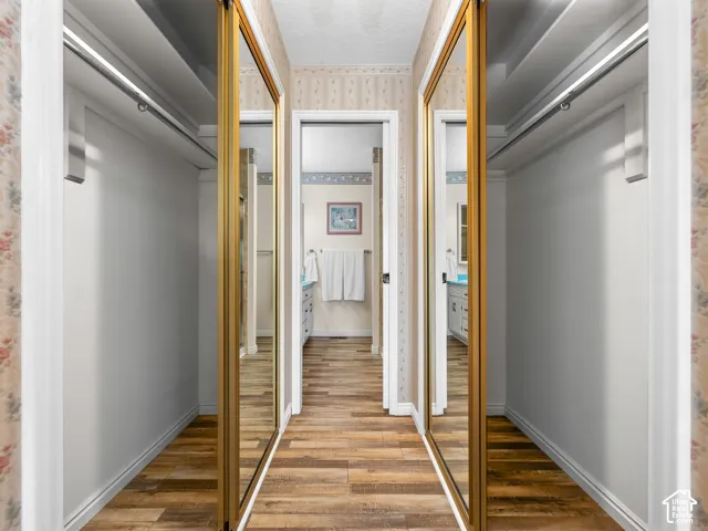Wood-finish flooring leading to a bathroom with a light blue countertop