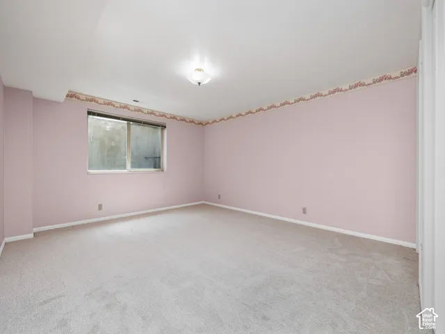 Recessed window, ceiling-mounted light fixture, light-toned carpeting, and painted walls