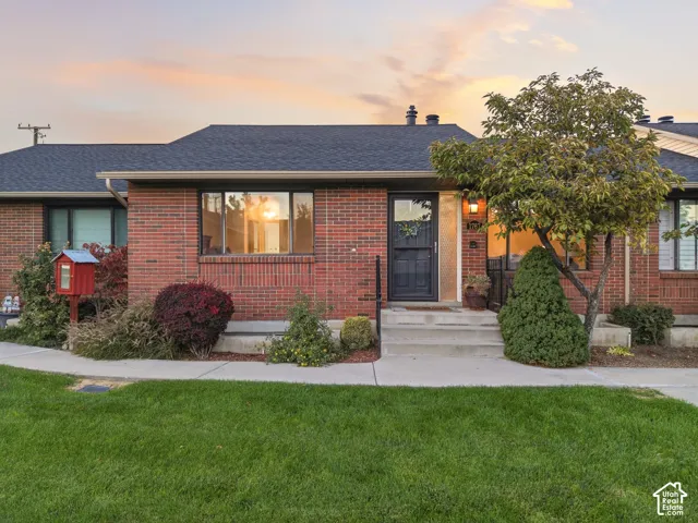 Single-story brick exterior featuring a multi-gabled roofline, concrete entry steps, and a glass-paneled front door