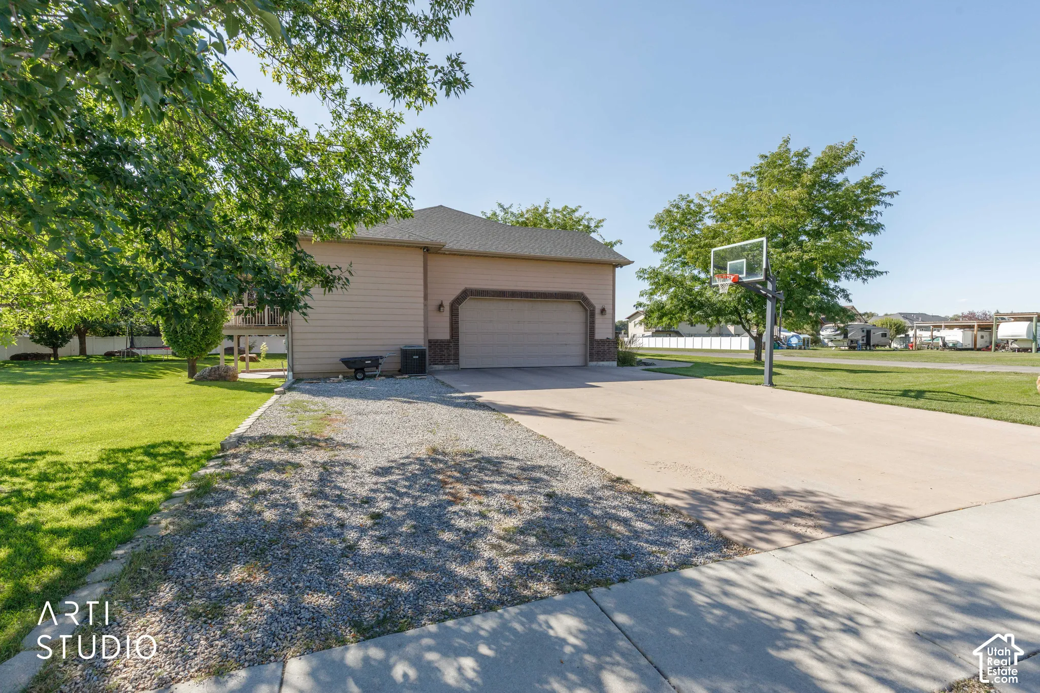Attached two-car garage, concrete driveway, gravel driveway, and expansive lawn