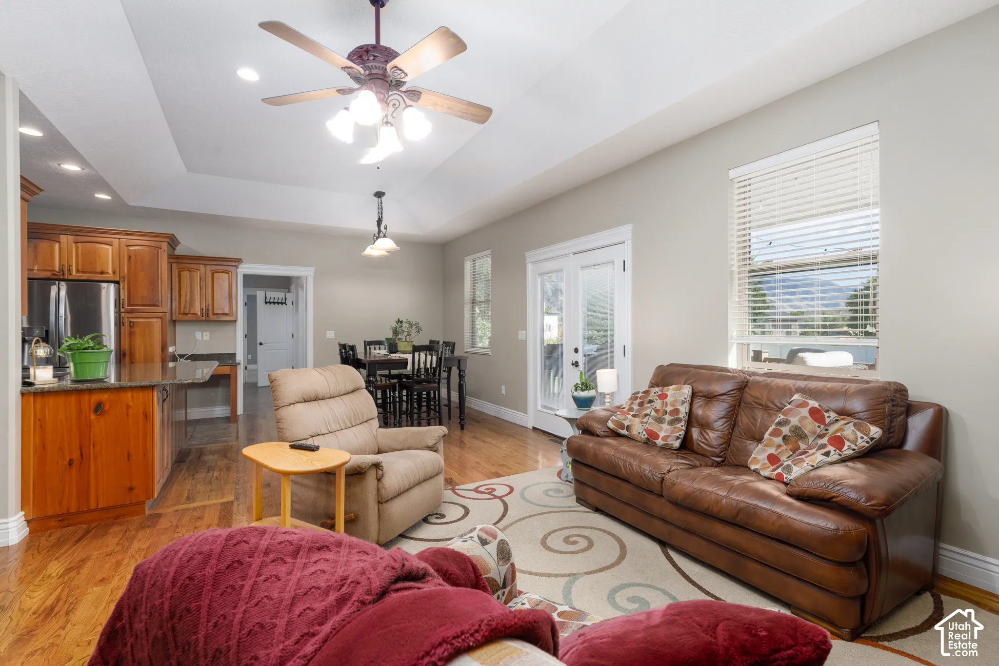 Tray ceiling with recessed lighting and a ceiling fan, wood-finish flooring, and light-toned wall paint