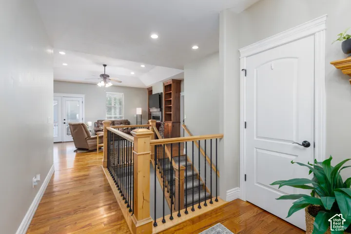 Hardwood flooring, recessed lighting, and a wood and iron staircase