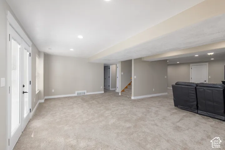 Recessed lighting, light gray carpet, and white trim throughout