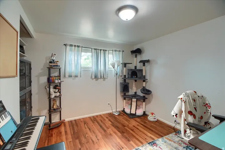 Hardwood-finish flooring, white walls, and a flush-mount ceiling light fixture