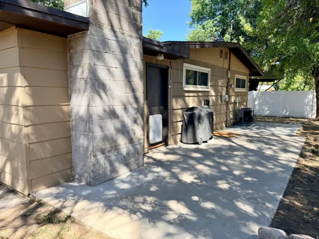 Expansive concrete patio with block chimney and horizontal siding