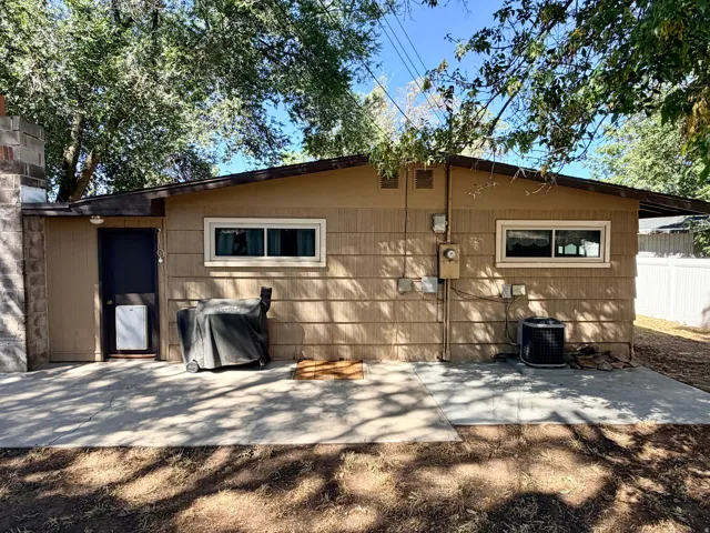 Exterior featuring horizontal siding, multiple windows, and a concrete patio