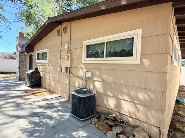 Beige horizontal siding and stone veneer exterior with multiple windows