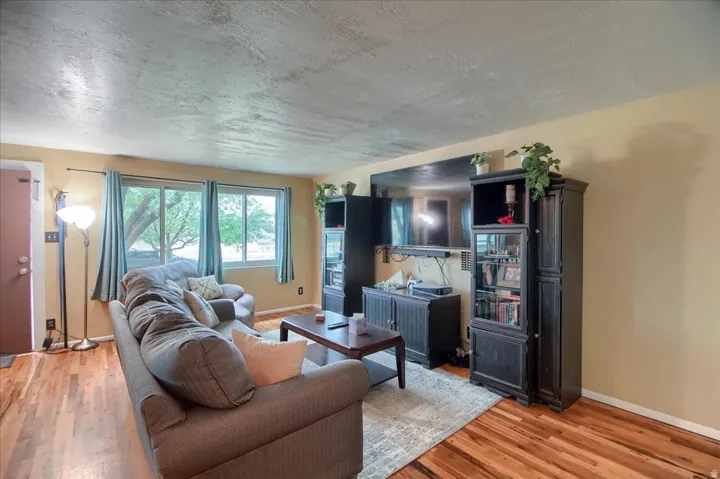 Wood-finish flooring throughout, multiple windows providing natural light, and a built-in media center with display cases
