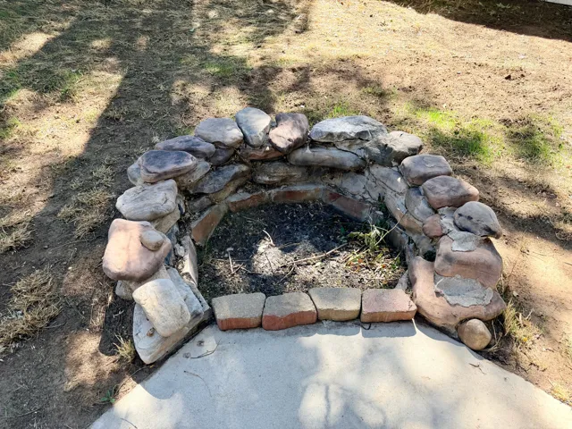 Stone-lined fire pit with a brick base