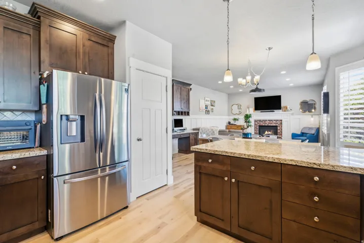 Kitchen island with a light-toned countertop, wood-finish cabinetry, and pendant lighting