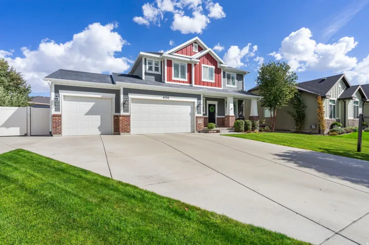 Two-story residence featuring a two-car garage, concrete driveway, and a front entry with a covered porch
