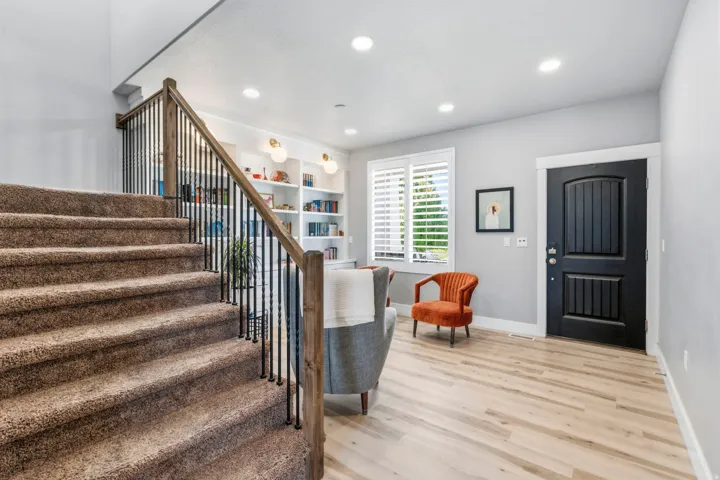 Recessed lighting with light-toned wood-finish flooring