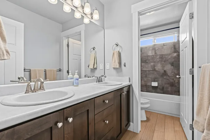 Dual vanity with undermount sinks, wood-finish cabinetry, and brushed nickel fixtures