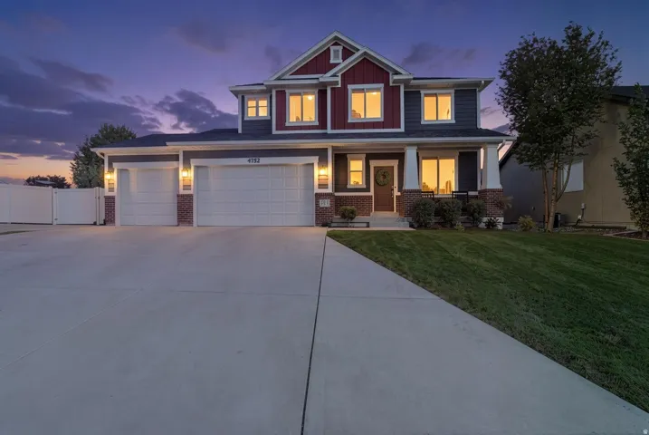 Two-story Colonial home with a two-car attached garage, concrete driveway, and manicured front lawn