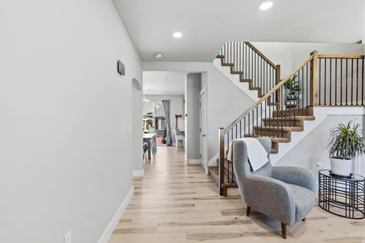 Staircase with wood newel posts, black iron balusters, and carpeted treads