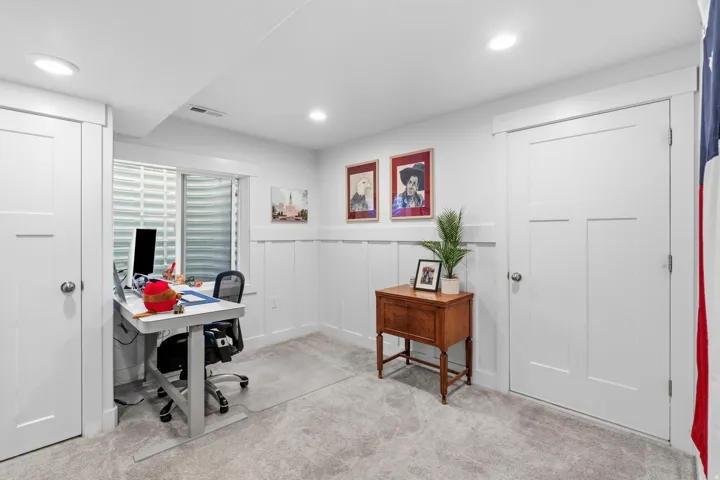 Recessed lighting, light gray carpeting, and board-and-batten wall detailing