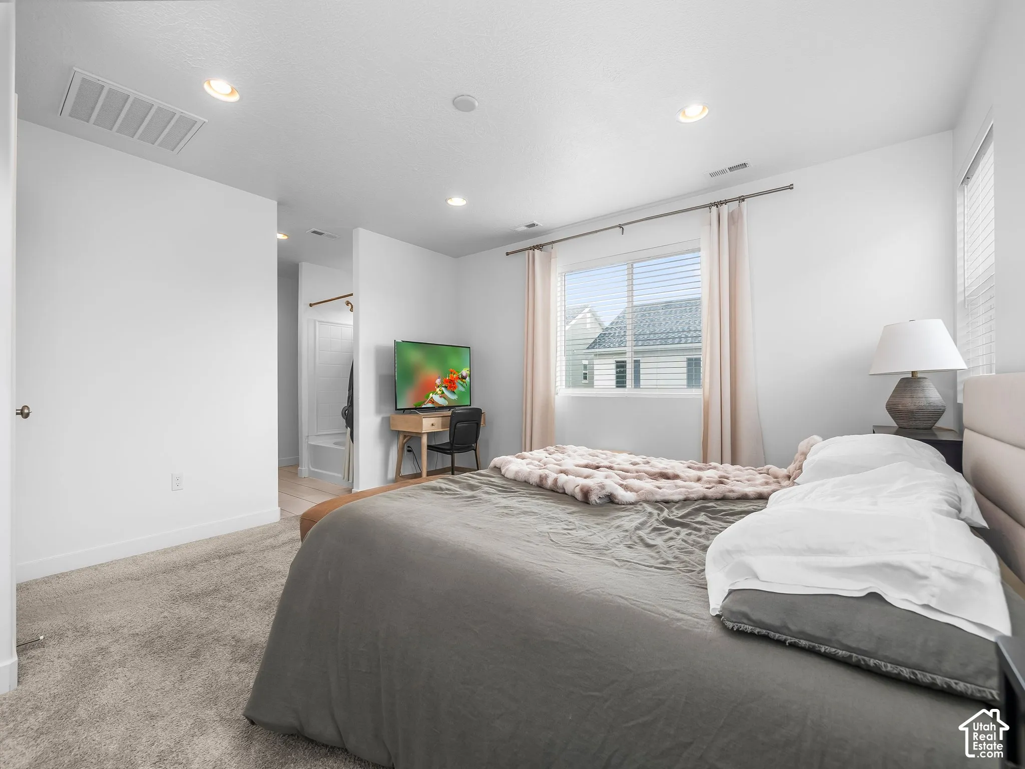 Recessed ceiling lighting, white walls, and a window with blinds and drapes