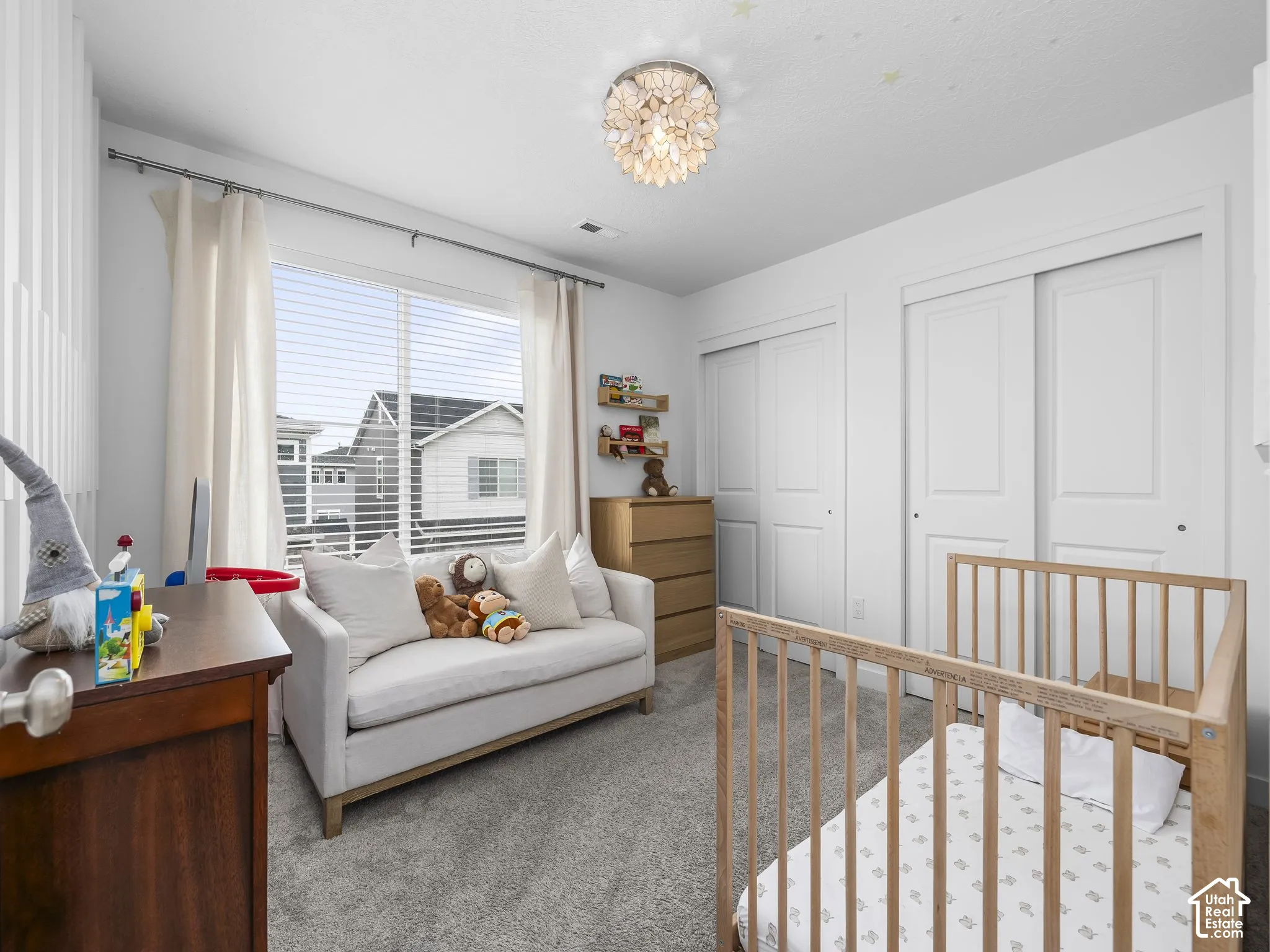 Recessed ceiling light, two white sliding closet doors, wood-finish flooring, and a large window with blinds