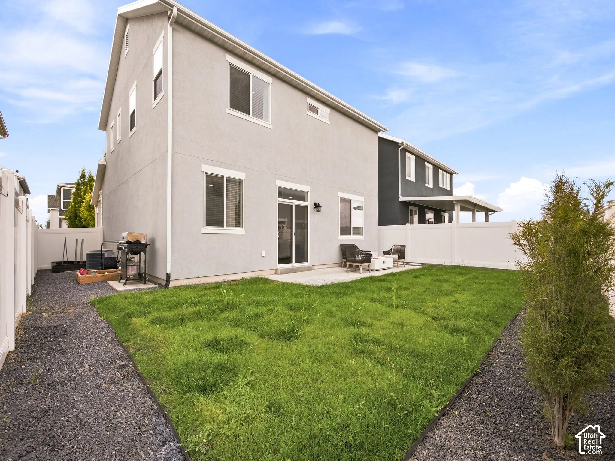 Private backyard featuring a concrete patio, sliding glass door, and vinyl fencing