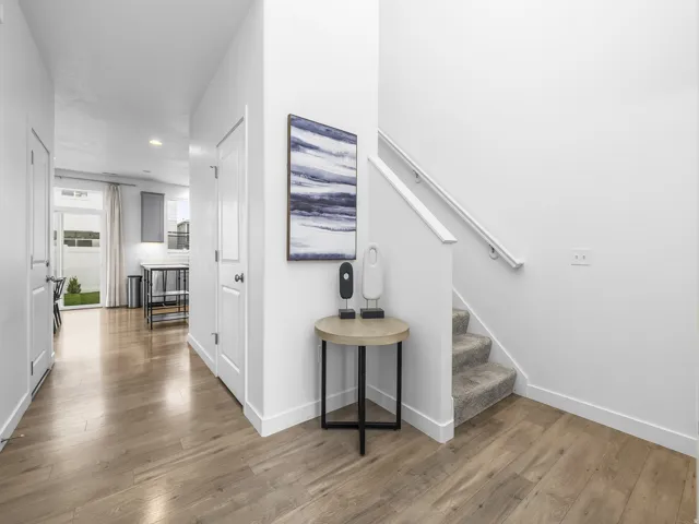 Bright hallway with wood-finish flooring, white painted walls, and recessed ceiling lighting