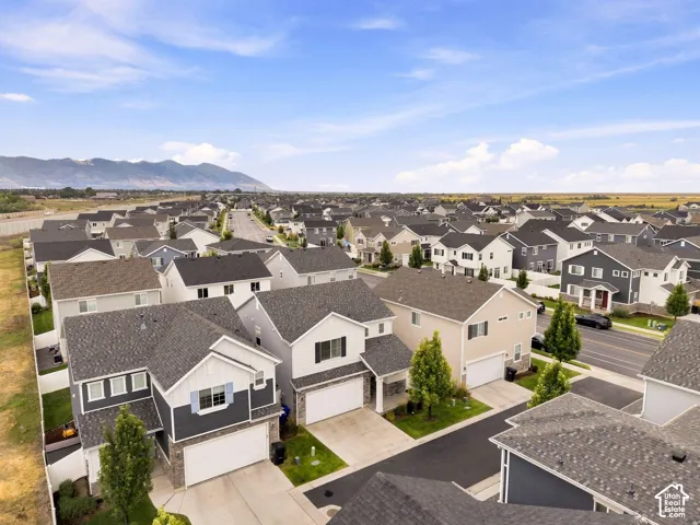 Expansive neighborhood with diverse architectural styles, visible mountain range, and clear skies