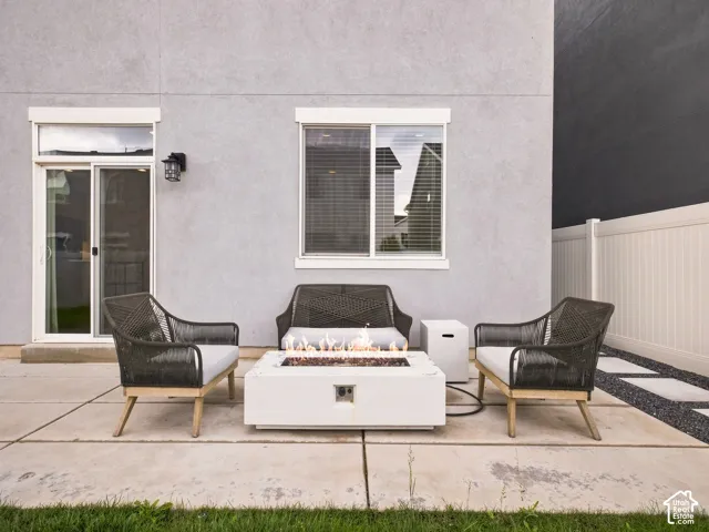 Patio featuring a fire pit, concrete pavers, and a white privacy fence