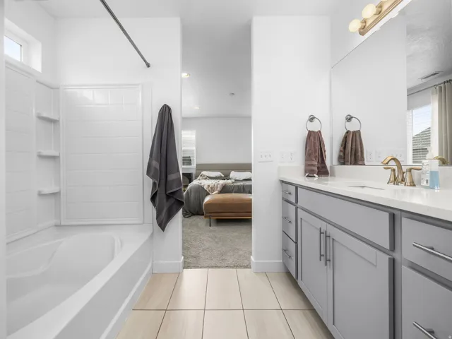 Bathroom featuring light grey vanity cabinetry, white countertop, and gold-finish fixtures