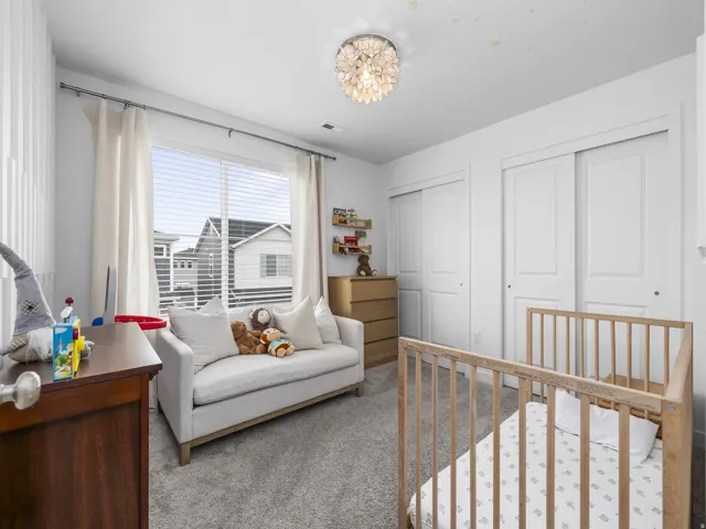 Recessed ceiling light, two white sliding closet doors, wood-finish flooring, and a large window with blinds