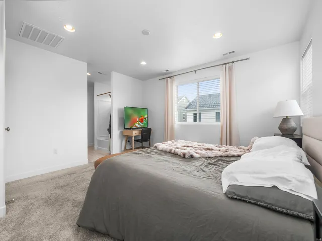 Recessed ceiling lighting, white walls, and a window with blinds and drapes
