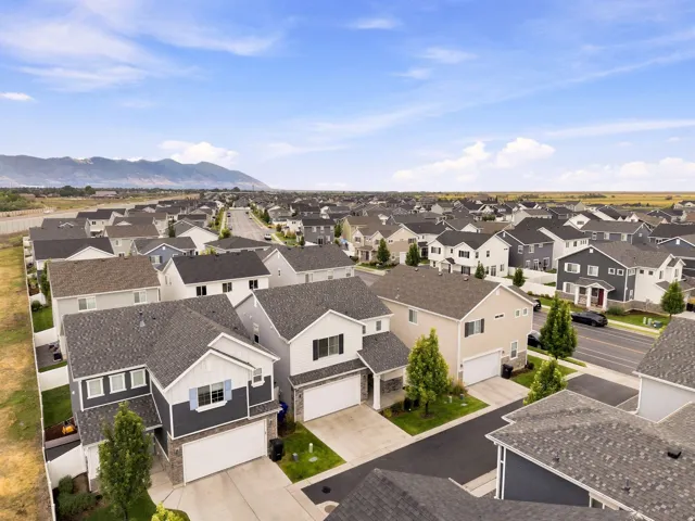 Expansive neighborhood with diverse architectural styles, visible mountain range, and clear skies