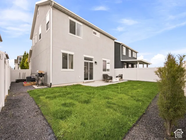 Private backyard featuring a concrete patio, sliding glass door, and vinyl fencing