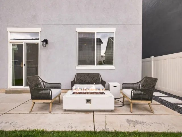 Patio featuring a fire pit, concrete pavers, and a white privacy fence